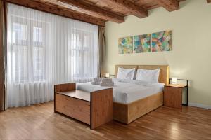 a bedroom with a large bed with white sheets at Schloss Haus Boutique in Braşov