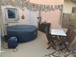 a patio with a hot tub and a table and chairs at Chambre double avec balcon in Sérignan +15 photos
