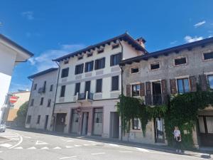 a woman standing in front of a building on a street at Affittacamere La Polse in Osoppo