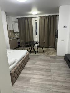 a room with a bed and a table and chairs at Pollux Residence Militari Ap 81 in Bucharest