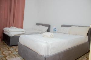 ein Schlafzimmer mit zwei Betten, auf denen Handtücher liegen in der Unterkunft LRx in Chimoio + 5 Fotos