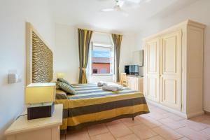 a bedroom with a large bed and a window at A.I.R. Hotel Gabbiano in Isola Rossa