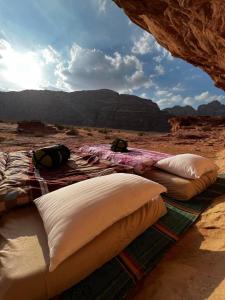 a group of pillows on a blanket in the desert at Lawrence Luxury Camp in Wadi Rum