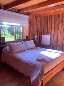 a bedroom with a large bed in a log cabin at Kumewe Lodge & Cabañas in Panguipulli
