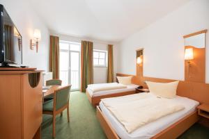 a hotel room with two beds and a television at Hotel Bitburger Hof in Bitburg