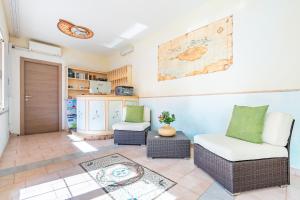 a living room with two chairs and a map on the wall at A.I.R. Hotel Gabbiano in Isola Rossa