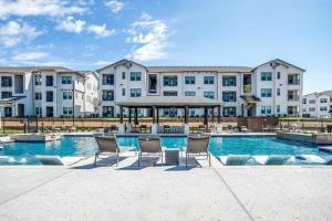 a pool with chairs in front of a building at Unit 232 Comfy 2BR 2BA Retreat in Cleburne