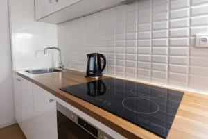 a kitchen with a sink and a coffee pot on a counter at Oporto City View - Santa Catarina in Porto +10 photos