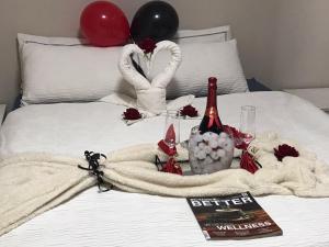 a bed with two balloons and a bottle of wine at Hideout River View Tent in Skeerpoort