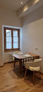 una sala da pranzo con tavolo e sedie e una finestra di Ginny a Bormio