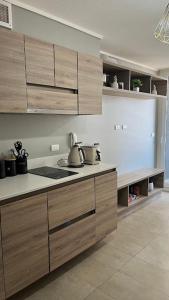 a kitchen with wooden cabinets and a counter top at Depa Céntrico con estacionamiento in Temuco +4 photos