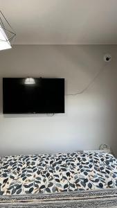 a bedroom with a bed with a tv on the wall at Depa Céntrico con estacionamiento in Temuco