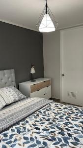 a bedroom with a bed with a blue and white comforter at Depa Céntrico con estacionamiento in Temuco
