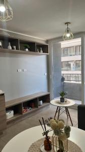 a living room with two tables and a large window at Depa Céntrico con estacionamiento in Temuco