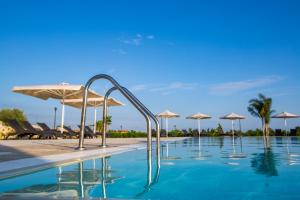 a swimming pool with umbrellas on a sunny day at Casal Sikelio in Cassibile
