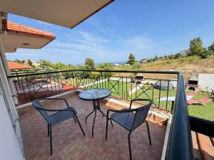 a patio with two chairs and a table on a balcony at Villa Mickey in Hanioti