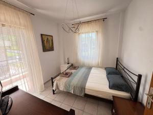 a bedroom with a bed and a large window at Villa Mickey in Hanioti
