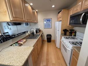 a kitchen with wooden cabinets and a white stove top oven at Family Ski Getaway in Kirkwood