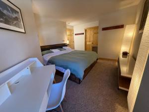 a bedroom with a bed and a desk and chairs at Family Ski Getaway in Kirkwood