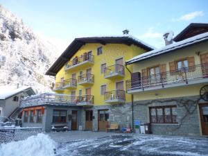 a yellow building with balconies on a mountain at Hotel Fior di Roccia in Gaby