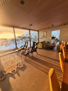 a room with chairs and a living room with a view at Lofoten Viewpoint 13 in Vestvågøya