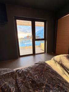 a bedroom with a bed and a large window at Lofoten Viewpoint 13 in Vestvågøya