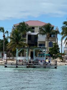 a house on a dock on a body of water at Jan's Hotel in Caye Caulker