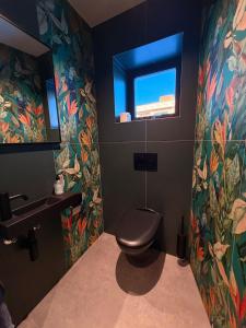 a bathroom with a toilet and a sink and a window at Lofoten Viewpoint 13 in Vestvågøya +23 photos