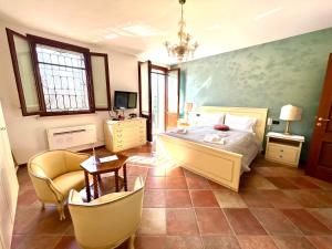 a bedroom with a bed and a chair and a tv at Villa Rita - Rooms&Art in Case Ghisiolo