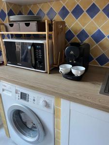 a kitchen counter with a microwave and a washing machine at De Gaulle 2 pièces Сentral Appartement in Cagnes-sur-Mer