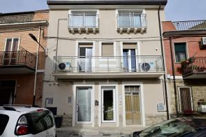 a white house with a balcony on top of it at Vista Normanna in Pietra Montecorvino
