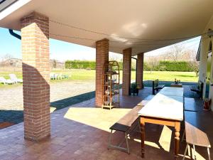 a patio with a table and a brick pillar at Villa Rita - Rooms&Art in Case Ghisiolo