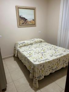 a bed in a bedroom with a blanket on it at Casa do Rio in Morretes