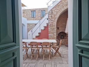 a table and chairs in a courtyard with a staircase at Symi Village House in Symi