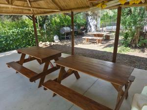 a picnic table and benches under a pavilion at Cabañas La Belen in Merlo
