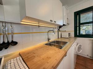 a kitchen with a wooden counter top and a sink at Cala Tatina in Celorio