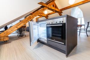 a kitchen with a stainless steel oven and a staircase at Black Apartment - Large Spacious One Bedroom Penthouse Loft in Baden-Baden
