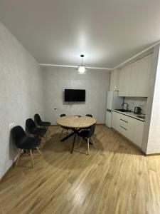a room with a table and chairs and a kitchen at Ander Tower in Stantsiya Batumi-Passazhirskaya