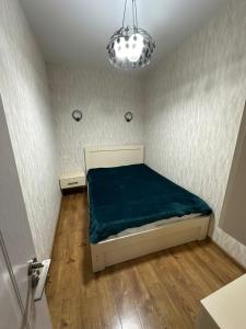 a small bedroom with a bed and a chandelier at Ander Tower in Stantsiya Batumi-Passazhirskaya