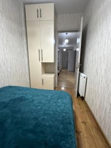a bedroom with a blue bed and a hallway at Ander Tower in Stantsiya Batumi-Passazhirskaya