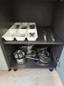 a shelf with dishes and utensils in a kitchen at Garibaldi Apartment Sanremo La Piazzetta in Sanremo
