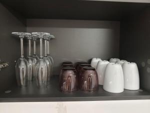 a shelf with glass vases and cups on it at Garibaldi Apartment Sanremo La Piazzetta in Sanremo