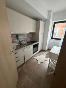 a kitchen with white cabinets and a sink and a table at Resident aparments two bed with balcony in Bucharest