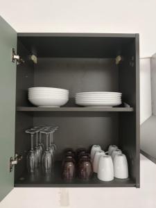 a cupboard with plates and dishes in it at Garibaldi Apartment Sanremo La Piazzetta in Sanremo