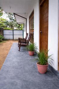 a porch with two chairs and two potted plants at South View residence 02 in Busse