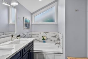 a white bathroom with two sinks and a tub at 4922 Turtle Point in Kiawah Island +36 photos