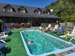 a group of children playing in a swimming pool at Jaśkowa Chata Bieszczady apartament z basenem nr 1i2 in Baligród
