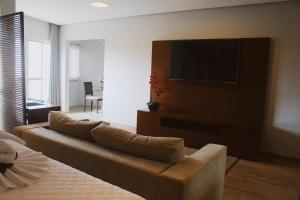 a living room with a couch and a flat screen tv at Hotel Canoeiros in Pirapora