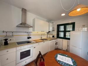 a kitchen with white cabinets and a wooden table with a wooden table at Cala Tatina in Celorio +11 photos