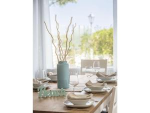 a wooden table with a blue vase on top of it at Strandburg "Aquamarin" 01 a in Burgtiefe auf Fehmarn  +13 photos